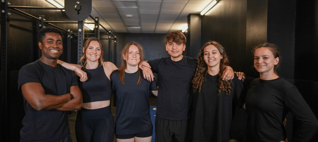 Photo de groupe des apprenants BPJEPS AF à l'ENCP, 4 femmes et 2 hommes qui prennent la pause en souriant dans une salle de sport