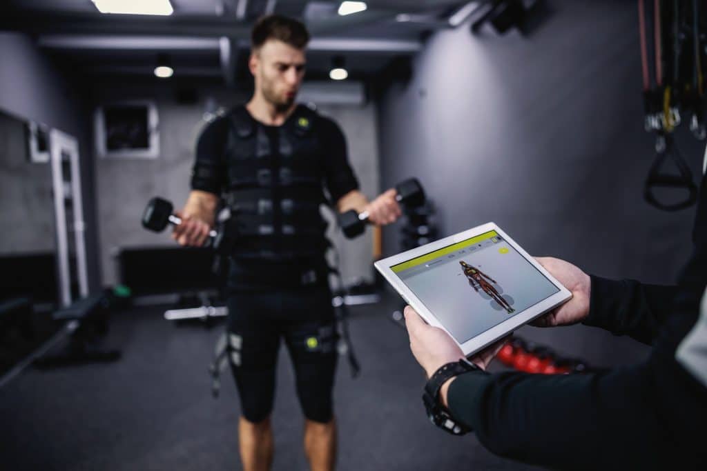 Homme entraînant avec électrostimulation et tablette.