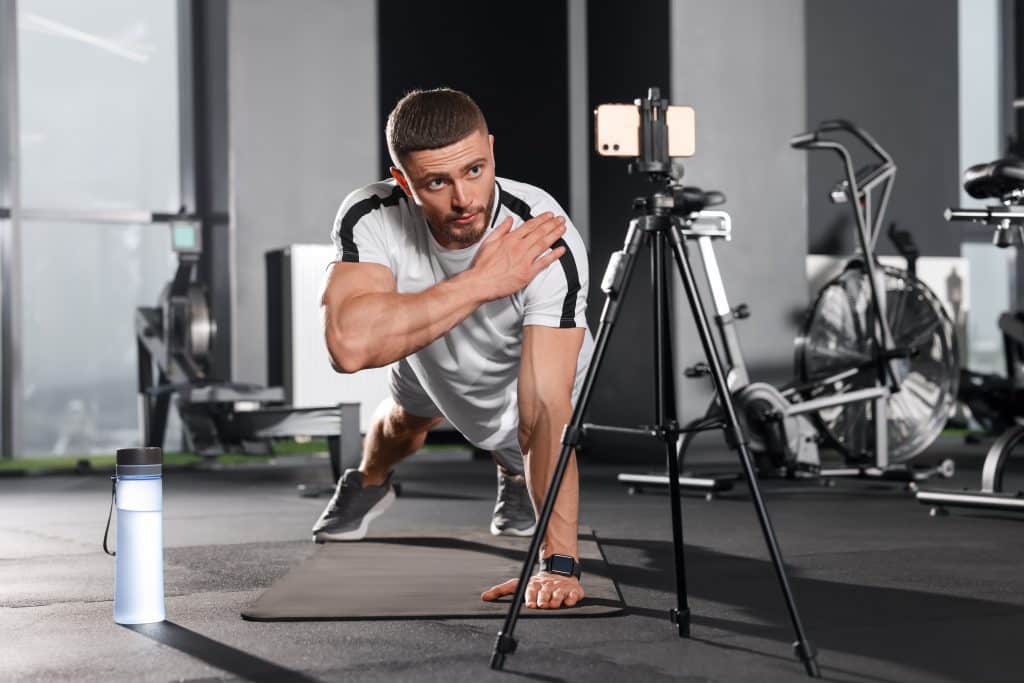Homme faisant du sport devant un smartphone.