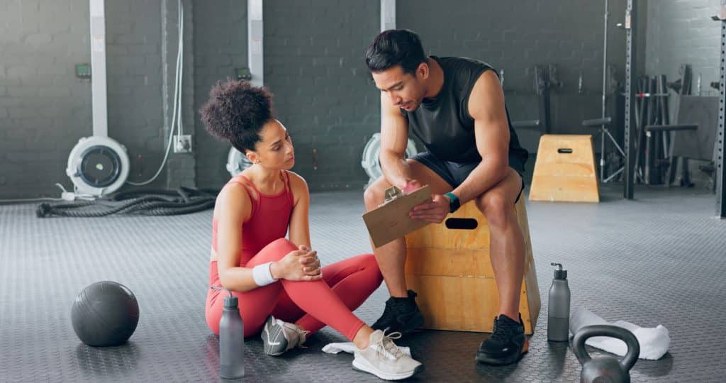 Coach discutant avec athlète au gymnase.