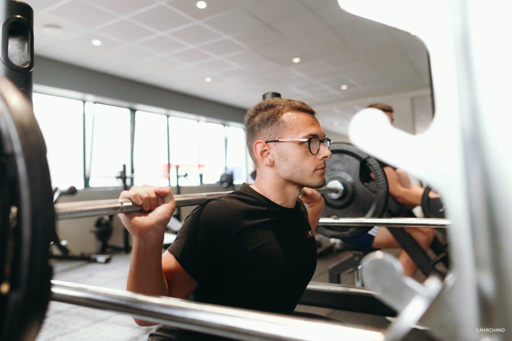 Homme soulevant des poids à la salle de sport.