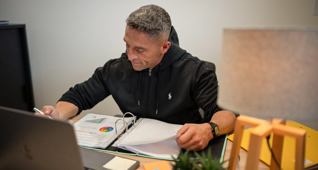 Homme travaillant à un bureau avec ordinateur portable.