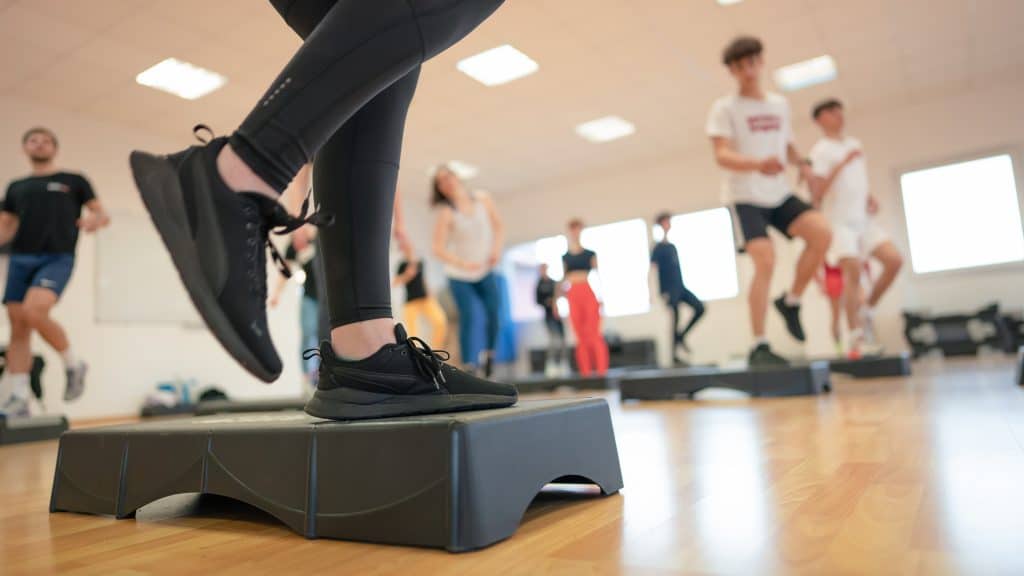 Personnes faisant des exercices step en groupe.