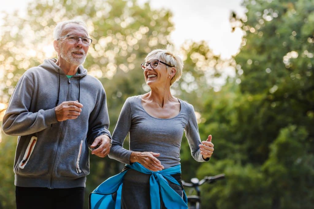 Couple âgé marche dans un parc.