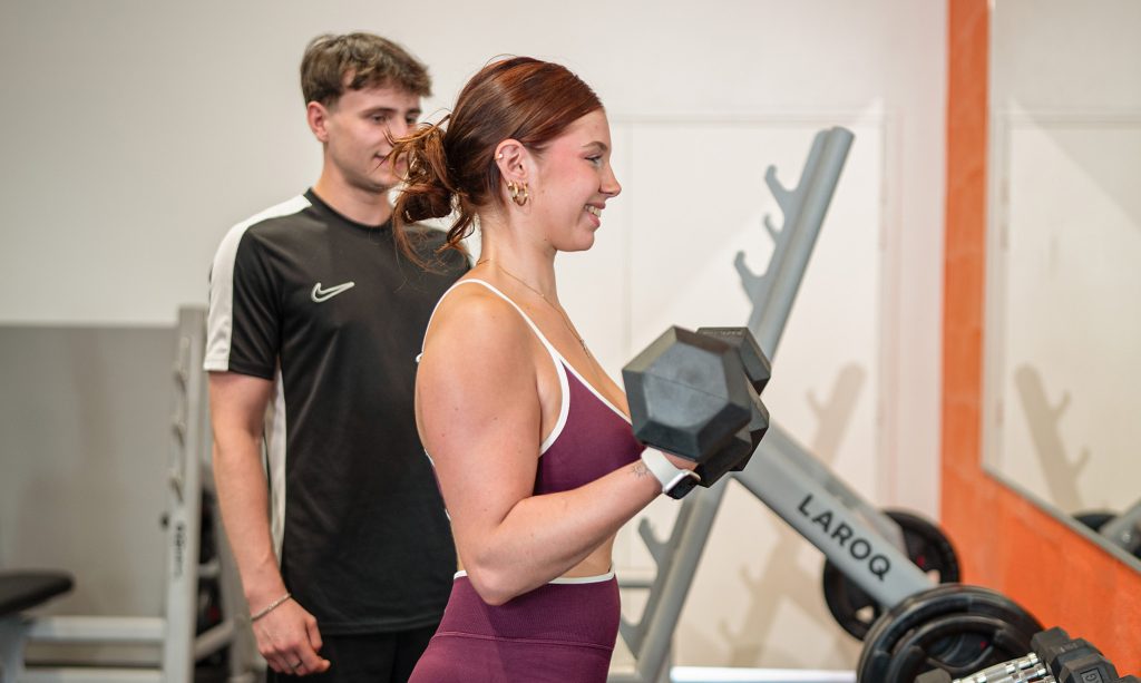a1 00012 2 Femme s'entraîne avec haltères au gymnase.