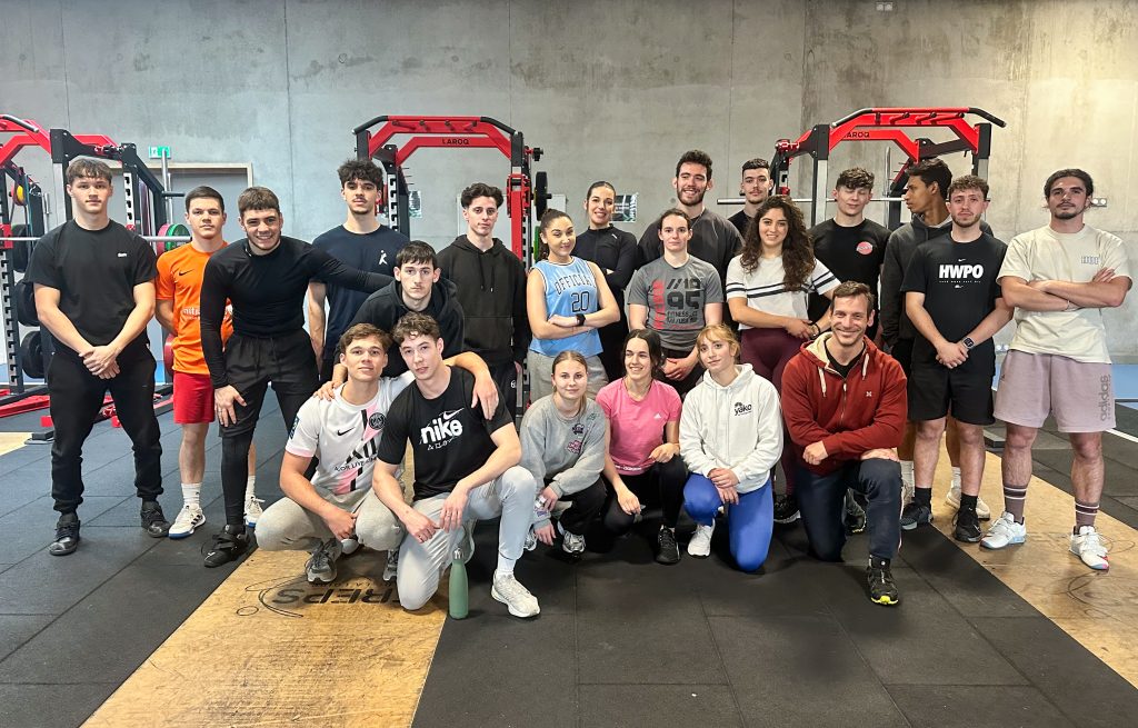 Groupe de personnes posant dans une salle de sport.