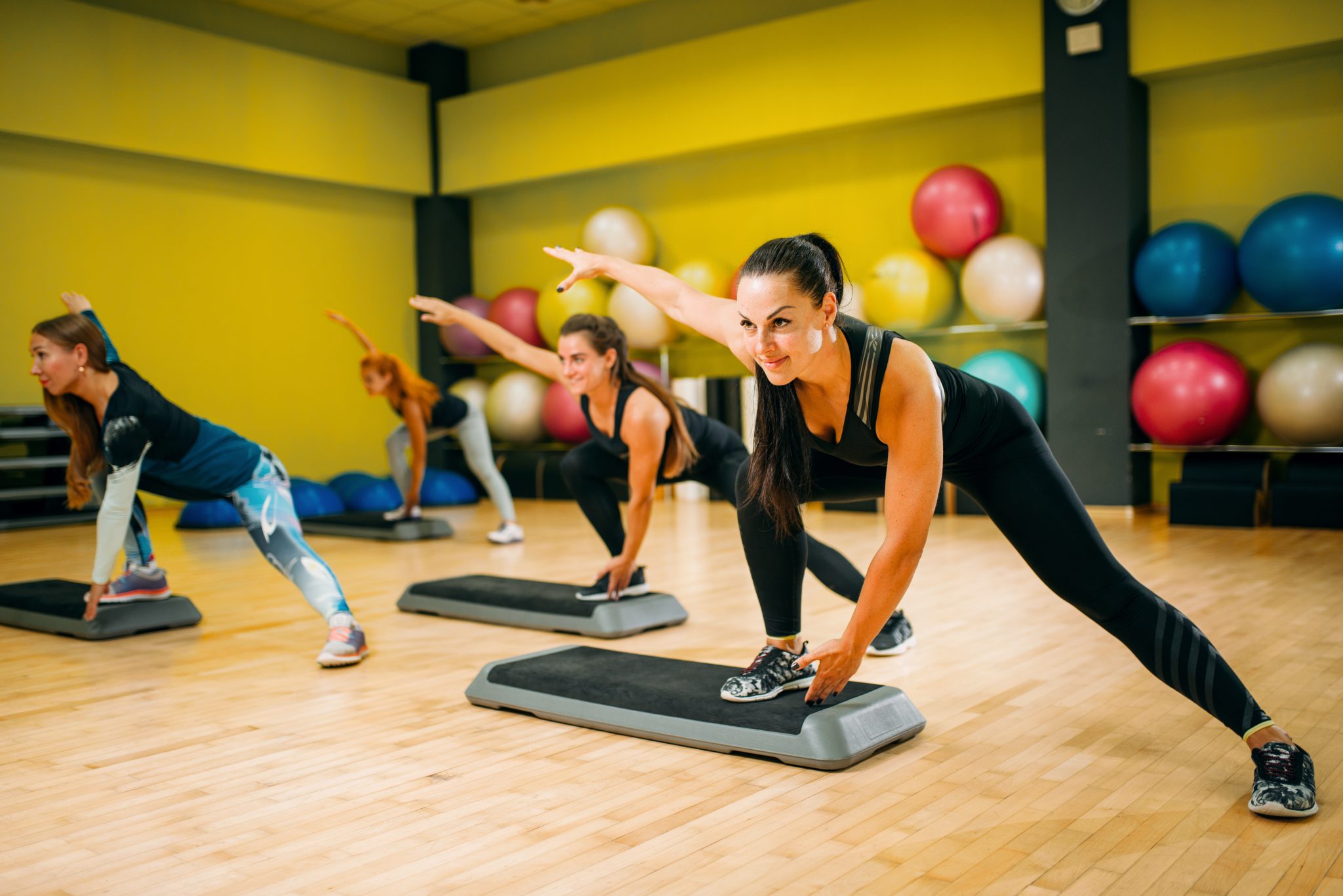 women group on step aerobic training Cours de step en salle de sport