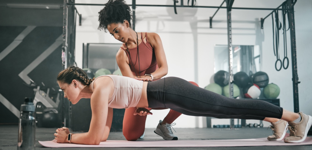 Coach corrige posture d’une femme en gainage